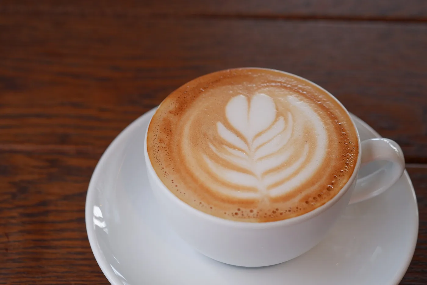 A cappuccino with latte art in a white cup. The photo was not taken at a Roswell cafe.